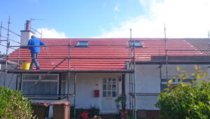 Workmen hosing down new tiled roof in Aberdeen